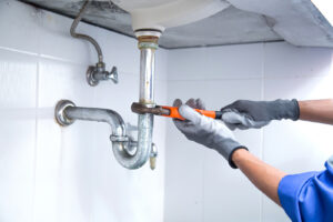 Plumber repairing an underground drain pipe in an older Melbourne home